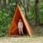 Bambino in piedi all'interno di Tipi Nature wooden house nel parco giochi in un ambiente boschivo