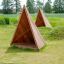 Riparo per parco giochi Tipi Nature wooden house realizzato in legno naturale su campo erboso.