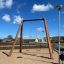 Nature Double Swing 5m in un parco giochi con struttura in legno e due sedili