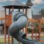 Attrezzatura da parco giochi Khumbu castle with slide in legno e metallo con uno scivolo grigio curvo.