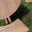 Round table & benches su sfondo erboso.