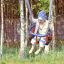 Bambino che si diverte su un Wooden Baby double swing in un parco giochi alberato
