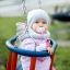Bambino seduto in Wooden Baby double swing all'aperto