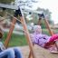 Bambini che si divertono sul 2+2 multiple swing in un parco giochi.