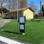 Attrezzatura interattiva per parco giochi Gas Pump su erba artificiale vicino a uno scivolo.