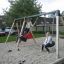 Bambini che giocano sul 1+2 multiple swing in un parco giochi.
