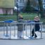 Giostra accessibile in sedia a rotelle con due bambini che giocano all'aperto con abiti invernali