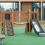 Casetta Mini Play II per bambini con parete da arrampicata in legno e scivolo nel parco giochi.