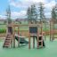 Casetta Mini Play II con scivolo su superficie verde del parco giochi, attrezzatura da parco giochi in legno per bambini