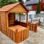 Wooden Garden Playhouse w/ Fencing in un cortile.