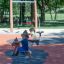 Due bambini che giocano su giochi a molla Pony rocking in un parco giochi
