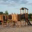 Struttura in legno per parco giochi Challenger Modern Nature single slide su superficie sabbiosa.