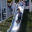 Bambini che giocano sullo scivolo Hill Slide h120 in un parco.