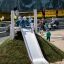 Bambini che giocano sullo scivolo Hill Slide h120 in un parco giochi.