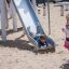 Bambino che scivola giù dallo scivolo Hill Slide h120 in un parco giochi.