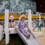 Bambini che giocano sullo scivolo Hill Slide h120 in un parco giochi.