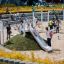 Bambini che giocano sullo scivolo Hill Slide h120 in un parco giochi affollato.