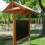 Aula all'aperto con panchine in legno, tetto parasole, lavagna e vasi per piante in un contesto di parco