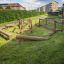 Attrezzatura da parco giochi in legno Ramp su un'area erbosa in una zona residenziale.