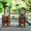 Forest Treehouse playhouse with slide su un parco giochi sabbioso circondato dal verde