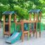 Forest Treehouse playhouse with slide realizzata in legno e con accenti verdi in un ambiente di parco giochi all'aperto