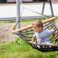 Bambino seduto su un Triple Hammock (Metal) in un parco.