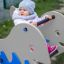 Bambino che gioca su Whale rocking gioco a molla nel parco giochi.