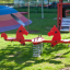 Double Pony rocking in un parco giochi colorato con erba e strutture da gioco sullo sfondo