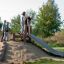 Bambini che giocano su Wooden Stair attrezzature da parco giochi con uno scivolo all'aperto.
