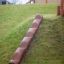 Wooden Stair elemento da arrampicata per parco giochi installato su una collina erbosa