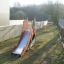 Attrezzature da parco giochi all'aperto Camel single slide installate in un'area giardino.