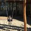 Bambino che si diverte sul Nature Double Swing in un parco giochi.