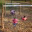 Bambini che giocano su Nature Double Swing in un parco durante l'autunno.