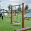 Altalena Singola in un parco giochi moderno con erba verde.