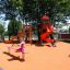 Attrezzatura da parco giochi rossa con scivoli e altalene a bilico.