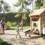 Bambini che giocano su attrezzature da parco giochi in legno Tambora Eco in un parco.