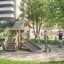 Bambini che giocano su attrezzature da parco giochi in legno Tambora Eco in un parco.