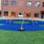 Attrezzatura da gioco Spinner II con archi arancioni e un palo centrale rotante su una superficie blu e verde s