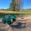 Attrezzatura da parco giochi verde Spinner III con accenti gialli in una giornata di sole.