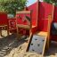 Attrezzatura da parco giochi in legno Barn con parete da arrampicata e pannello con motivo a cavallo