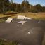 Skate park con rampe e ostacoli Curb Horizontal allestiti su superficie asfaltata.