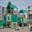 Tower playhouse with a slide in un parco giochi con bambini che giocano intorno