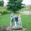 Tre bambini che giocano sull'attrezzatura da parco giochi Bee in un parco.