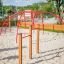 Rosso Cross Climber steel structure in un parco giochi con sabbia.