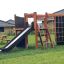 Struttura da gioco in legno per esterni Climbing Kiosk Nature con scivolo, scala e rete da arrampicata in giardino
