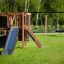 Climbing Kiosk Nature con scivolo e altalena in un parco erboso