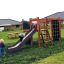 Bambini che giocano su attrezzature da parco giochi Climbing Kiosk Nature in un giardino.