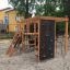 Struttura da parco giochi Climbing Kiosk Nature con telaio in legno, reti da arrampicata e parete di roccia in una sabbia