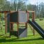 Struttura da arrampicata per parco giochi all'aperto Climbing Kiosk Nature con scivolo e pareti da arrampicata su un prato