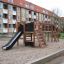 Parco giochi in legno all'aperto con scivolo e strutture da arrampicata, Romping Center Nature.